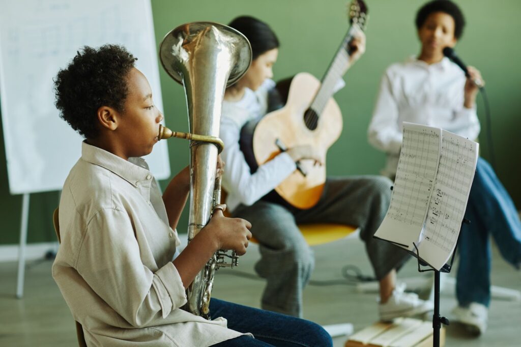 A children's music band performing, each child playing a different instrument